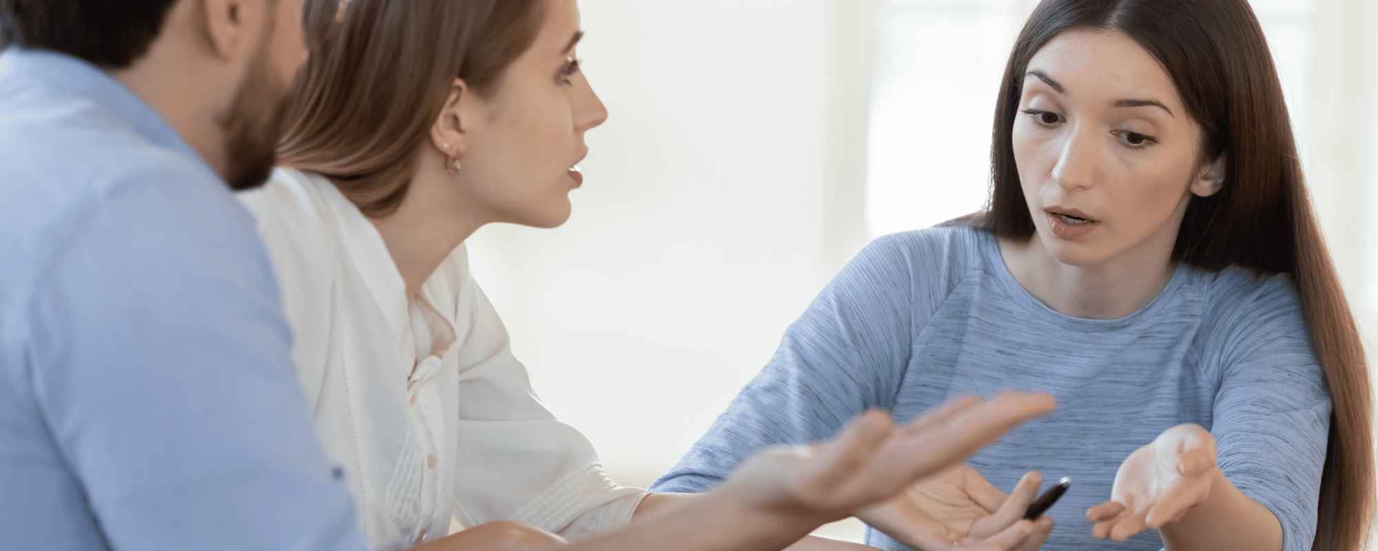 Two women displaying disagreeable faces as they engage in conversation.