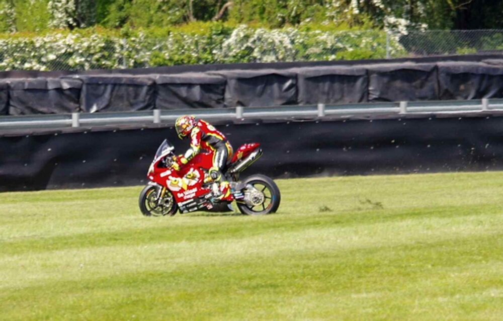 Landmark Ruling for 6 Times British Superbike Champion Shane Byrne Will Change Safety Forever in Motorcycle Racing An image of Shane Byrne, 6 Times British Superbike Champion, racing his red motorbike on a race track