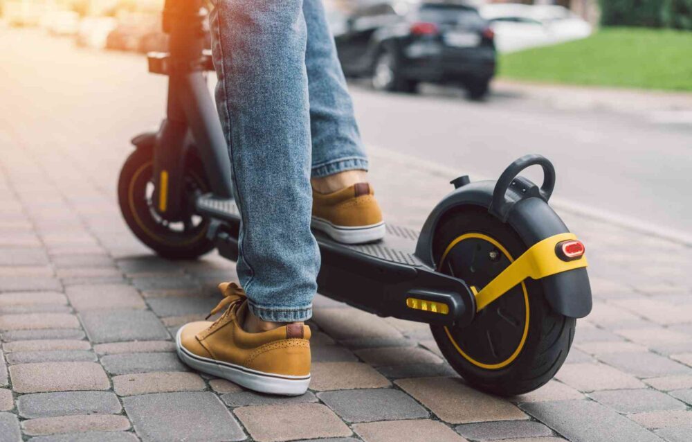 Safety Concerns for the Increased Sale of eScooters at Christmas A woman travels down a pavement on an e-scooter