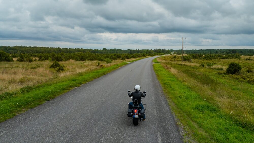 Motor biker on a country lane.